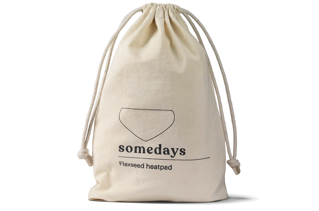 Product shot of the Somedays flaxseed heatpad inside its cotton pouch, highlighting the natural texture and packaging.