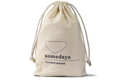 Product shot of the Somedays flaxseed heatpad inside its cotton pouch, highlighting the natural texture and packaging.