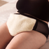 Lifestyle image of the Somedays teddy flaxseed heatpad placed on a woman&